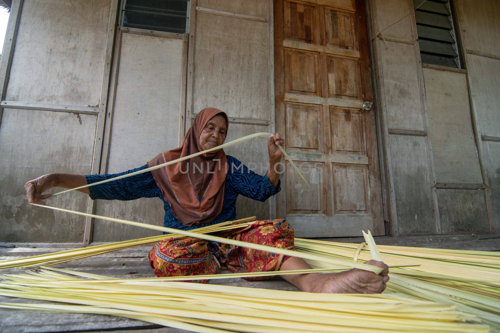 Kota Bahru, Kelantan/Malaysia - Jul 15 2017: An experience woman make cigarette from dried Nipah leaves.