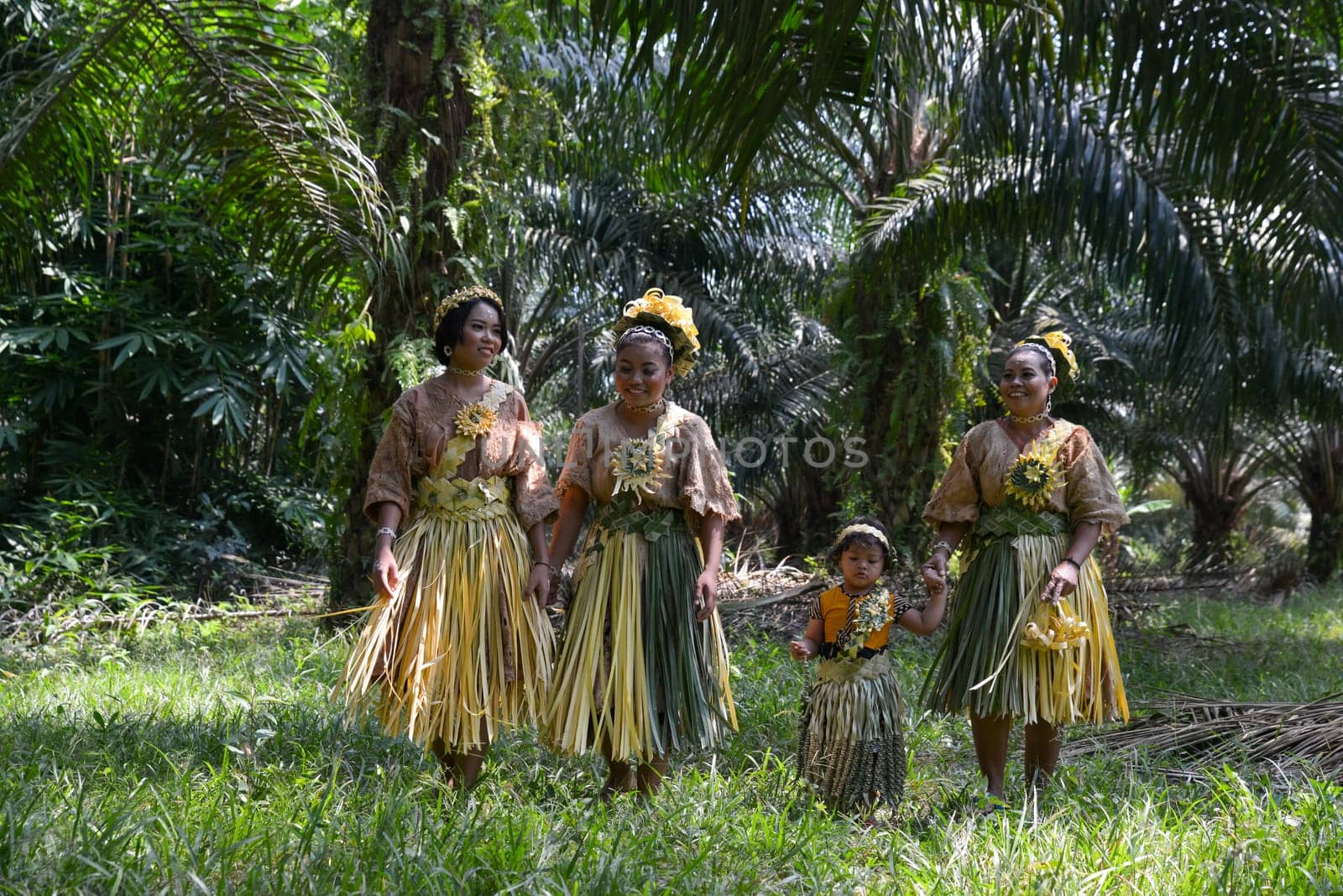 Carey Island, Selangor/Malaysia - Mar 17 2018: Malaysia's indigenous Mah Meri walk in oil palm plantation.