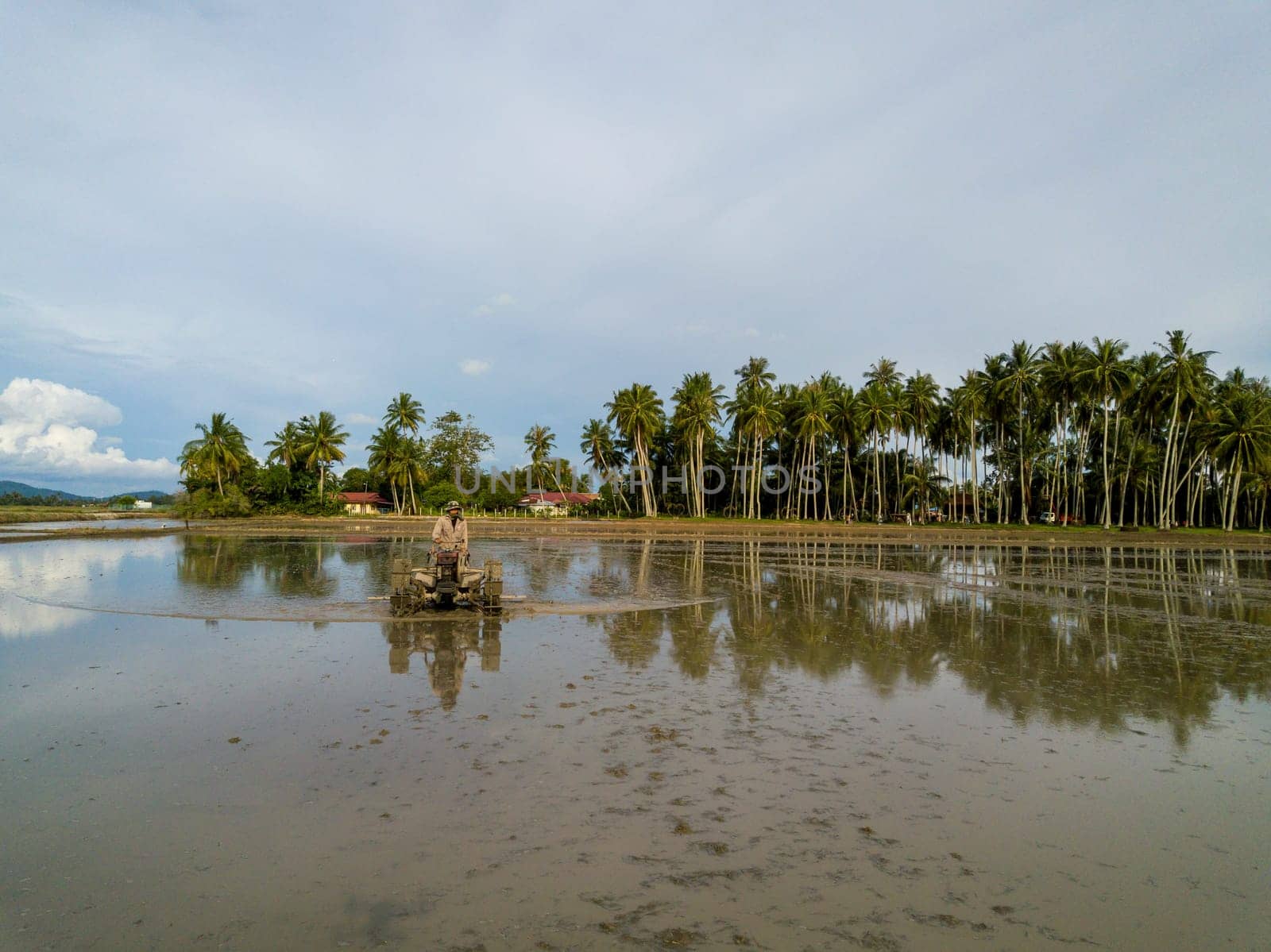 Penaga, Penang/Malaysia - Nov 02 2019: Reflection farmer work at field with tractor.