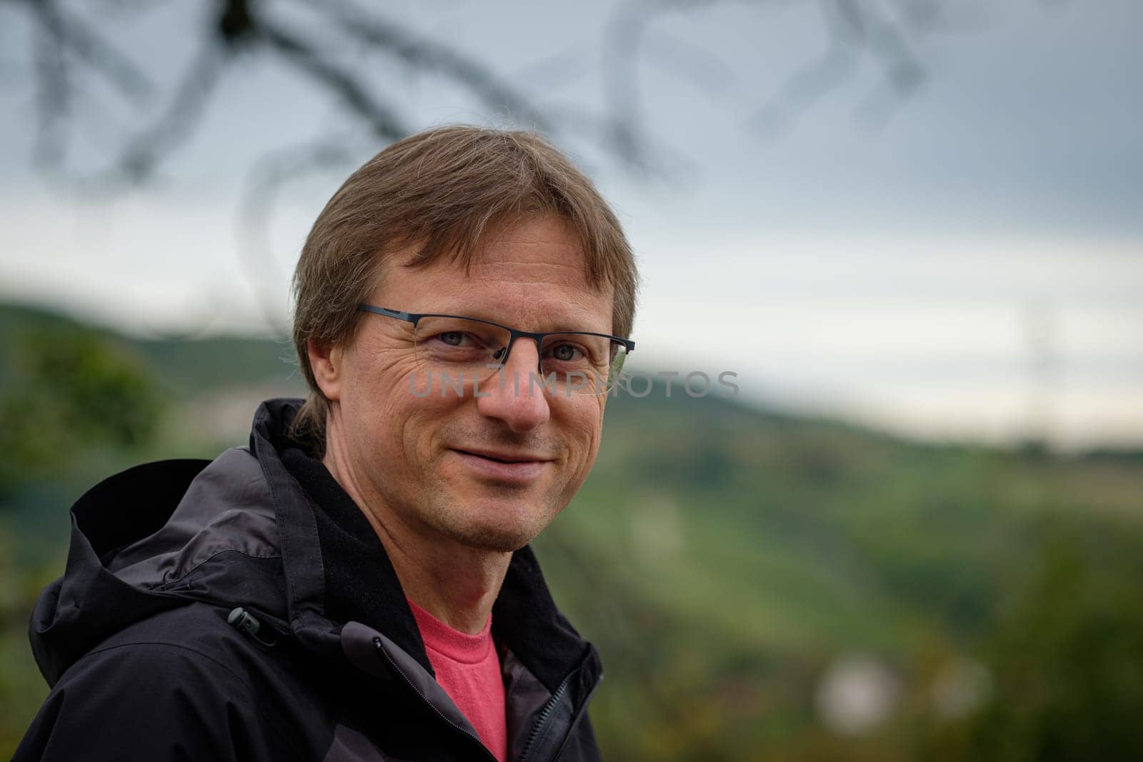 Smiling caucasian man with glasses and blurred landscape shot