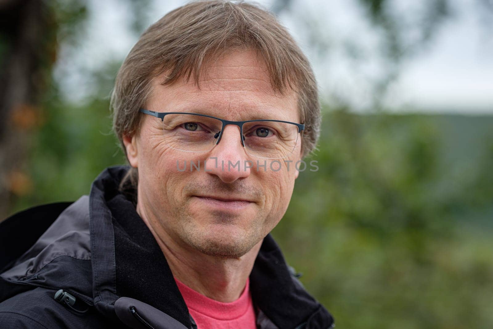 Portrait of a caucasian man with glasses and bokeh landscape