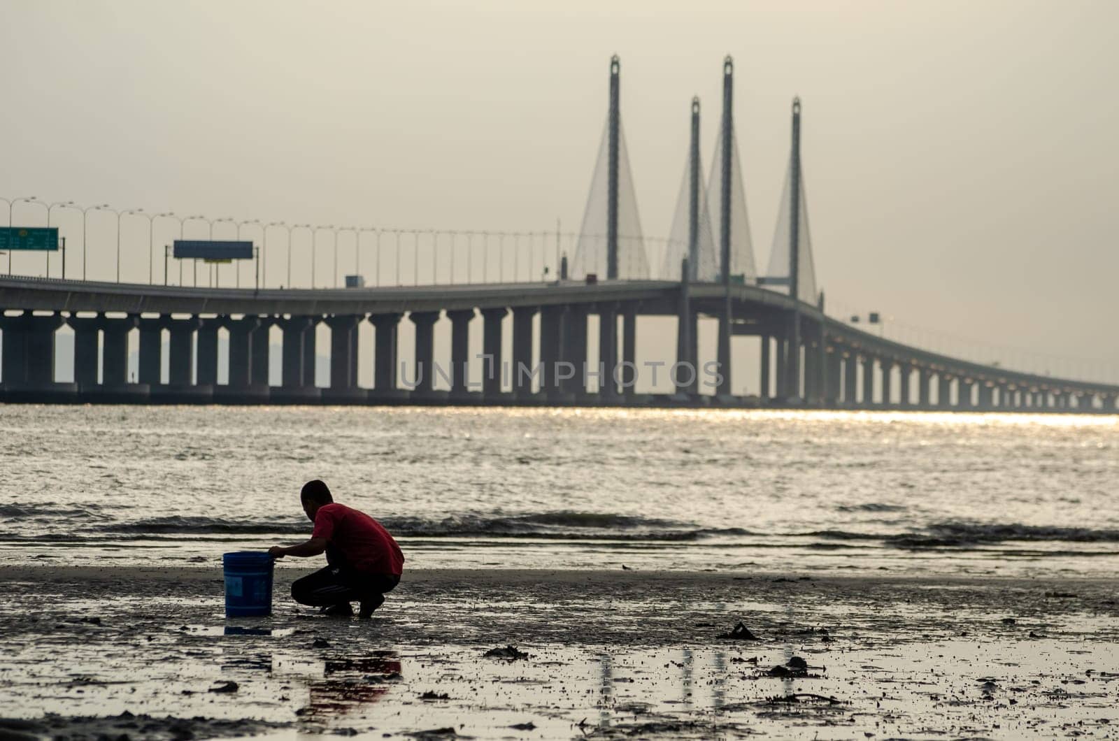 George Town, Penang/Malaysia - Dec 28 2019: Local dig clam with bucket near Penang second Bridge.
