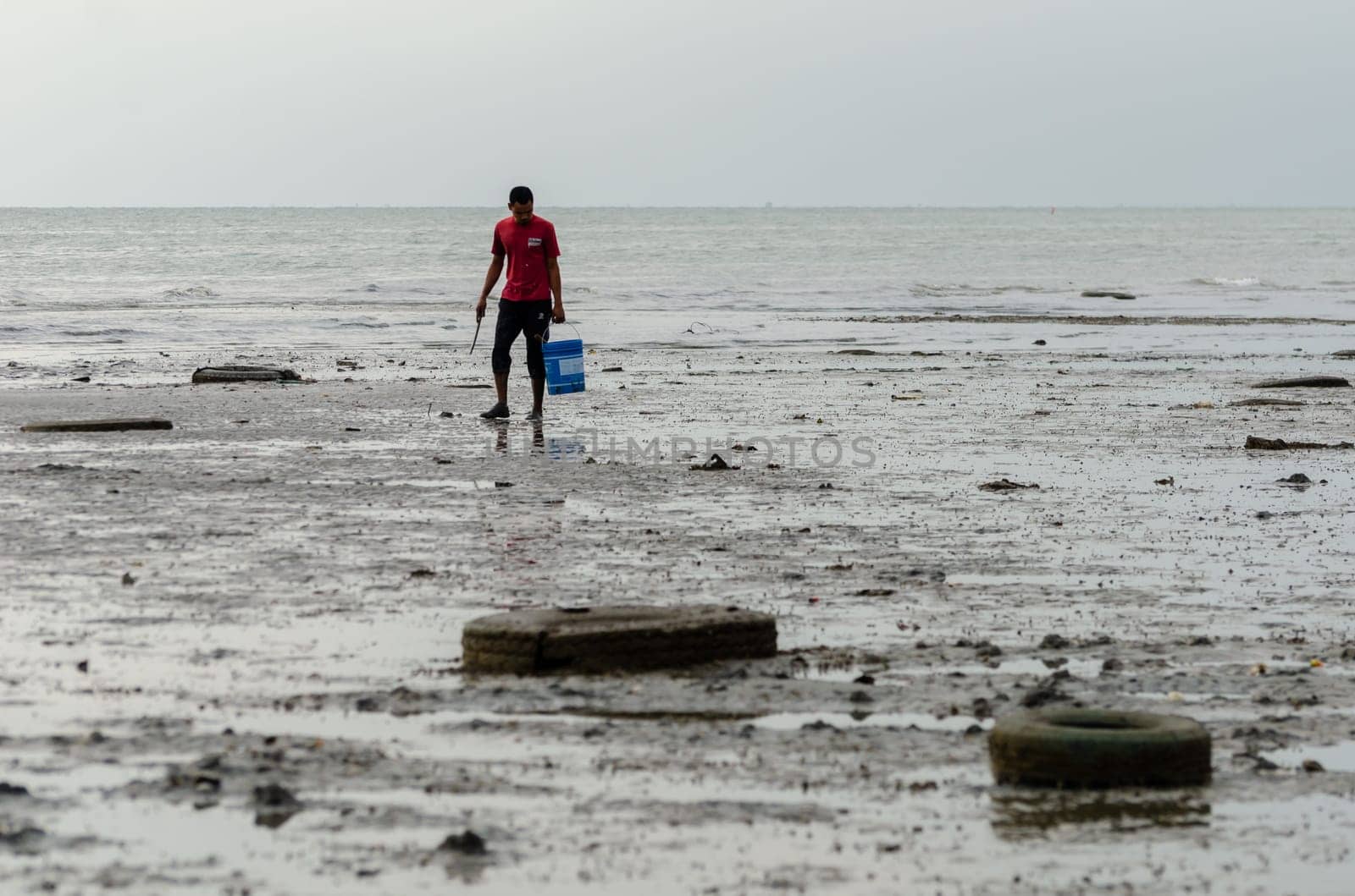 Batu Maung, Penang/Malaysia - Dec 28 2019: A fisherman search for clam.