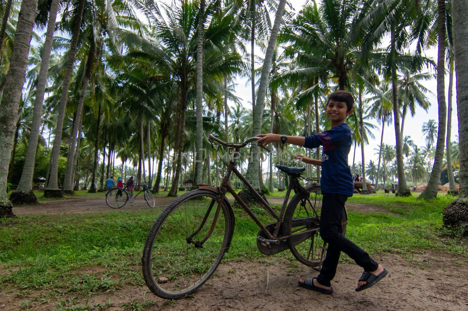 Penaga, Penang/Malaysia - Oct 27 2019: Kids walk with antic bicycle at coconut farm.