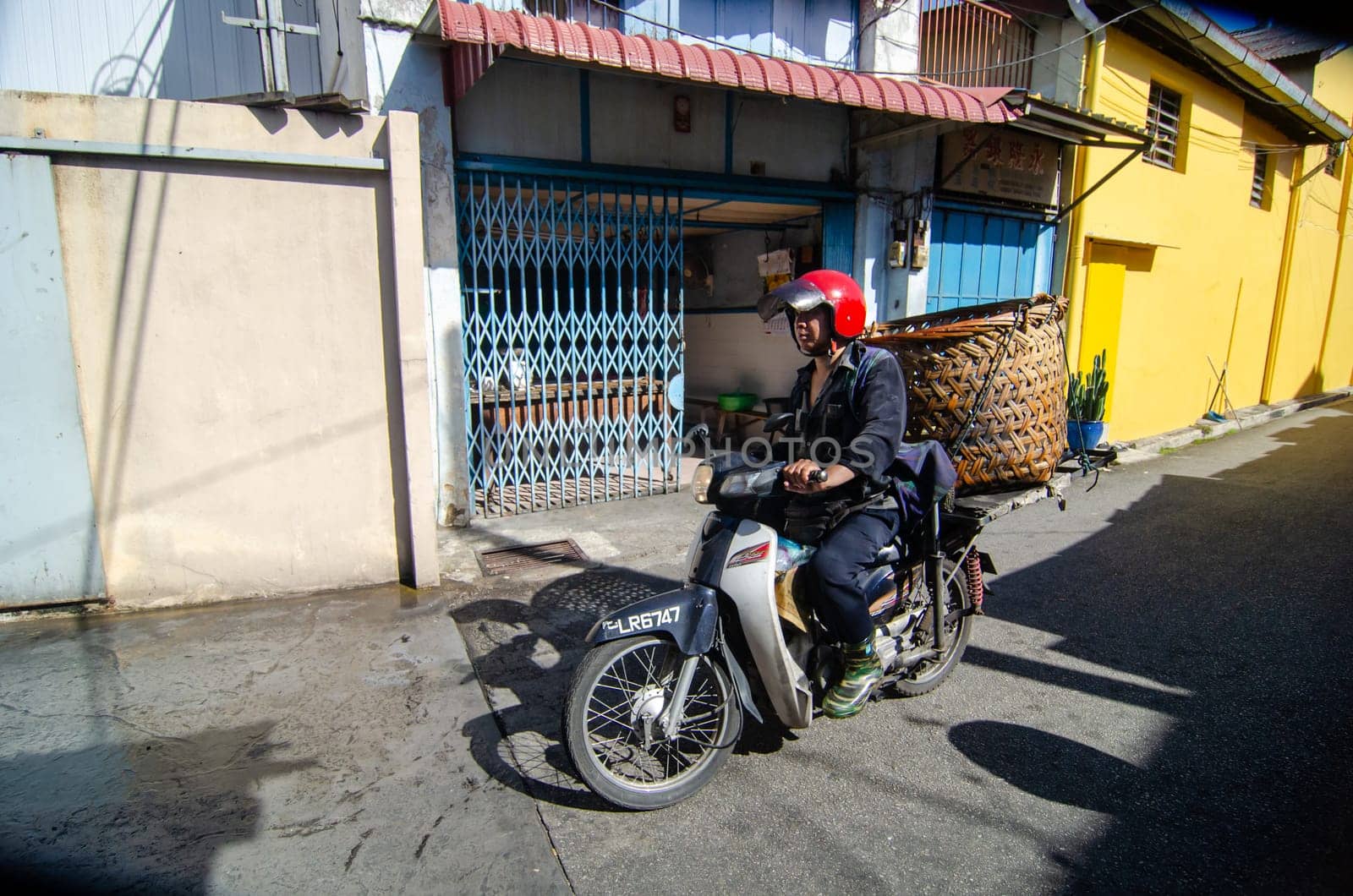 Bukit Mertajam, Penang/Malaysia - Jan 05 2020: A man ride the motor carry with big basket.