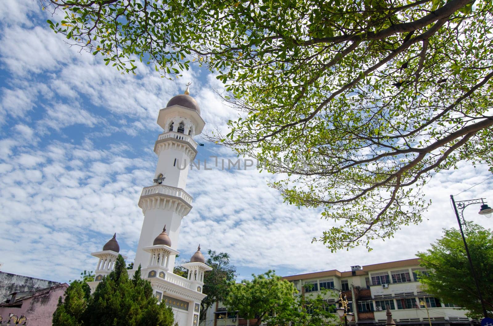 Georgetown, Penang/Malaysia - Feb 14 2020: Minaret Kapitan Keling Mosque with green leaves.