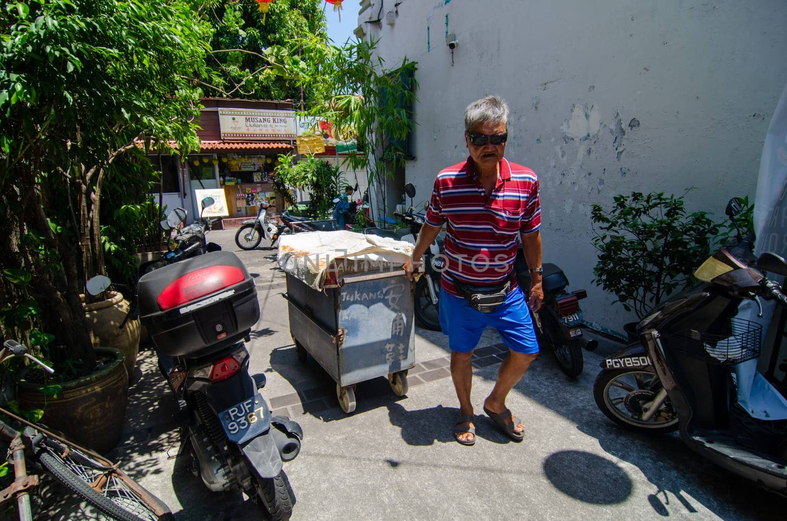 Georgetown, Penang/Malaysia - Feb 27 2020: A man repair show pull trolley at alley.
