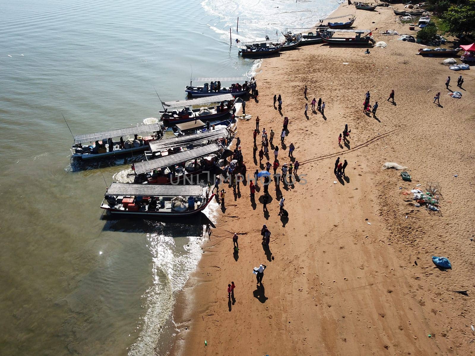Crowd come to the jetty buy fish.