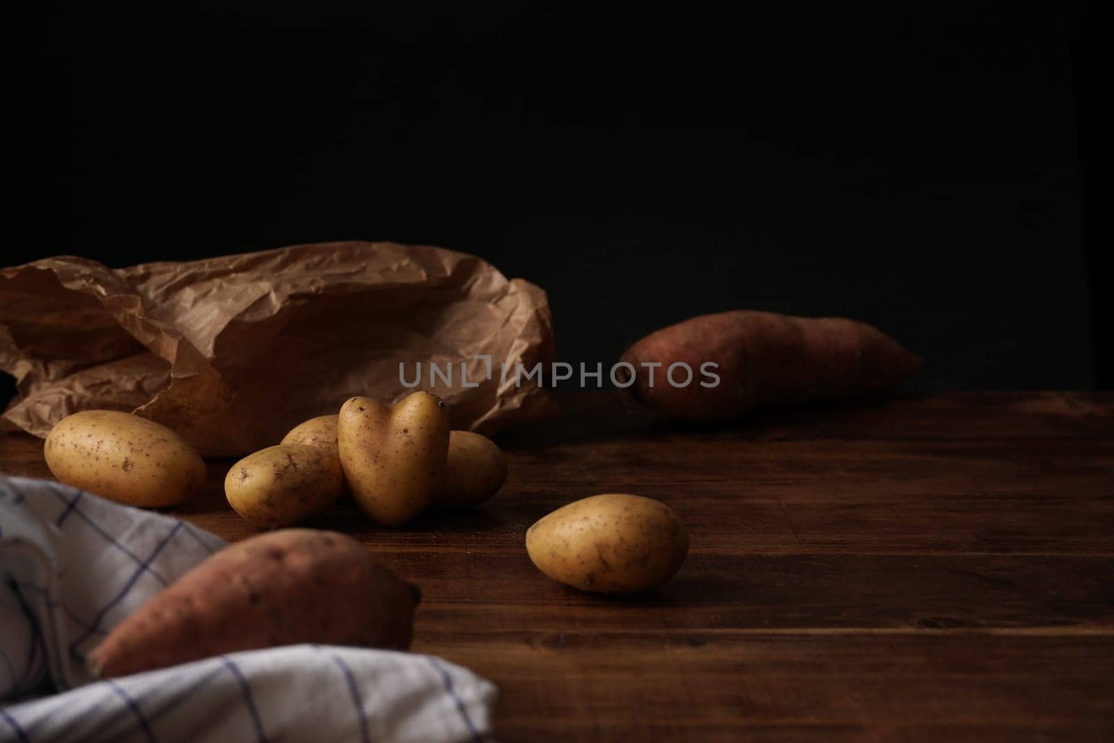 Seasonal food: Potatoes and Yam on wooden table (heart-shaped potato)