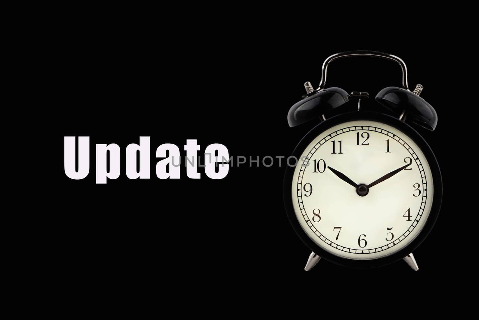 UPDATE text with alarm clock on black background. Business Concept