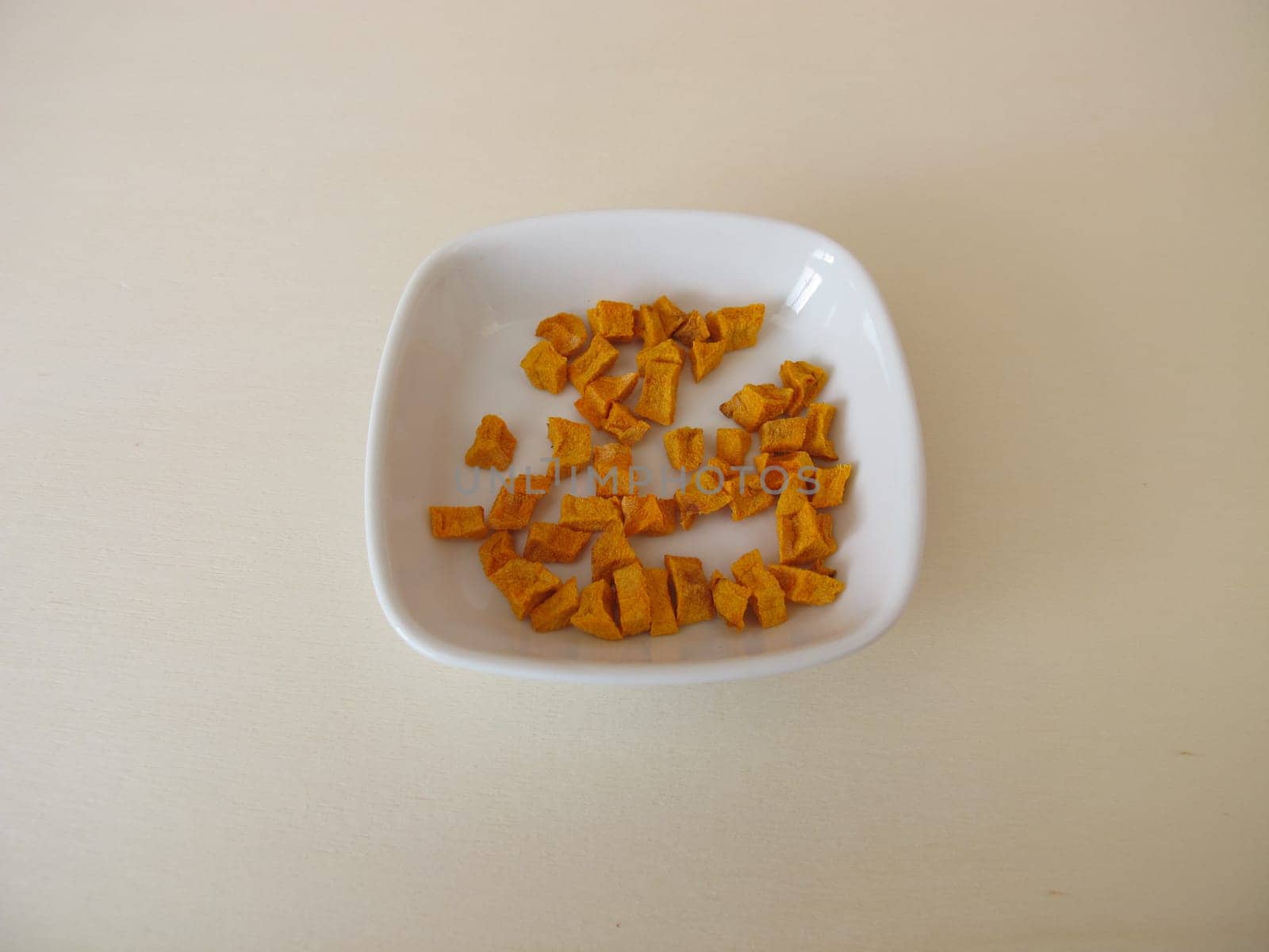 Dried turmeric, curcuma root on a wooden board