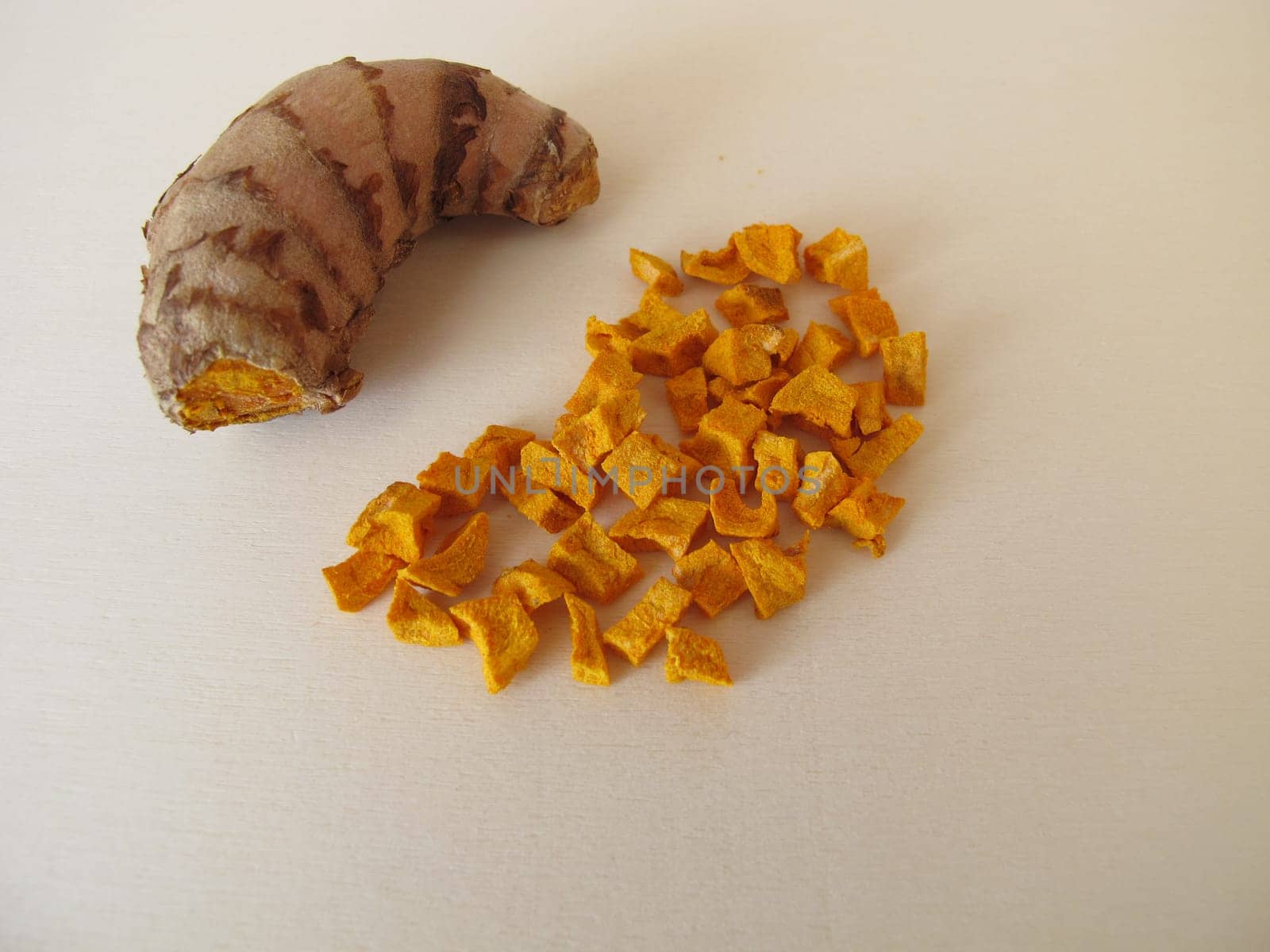 Dried turmeric, curcuma root on a wooden board