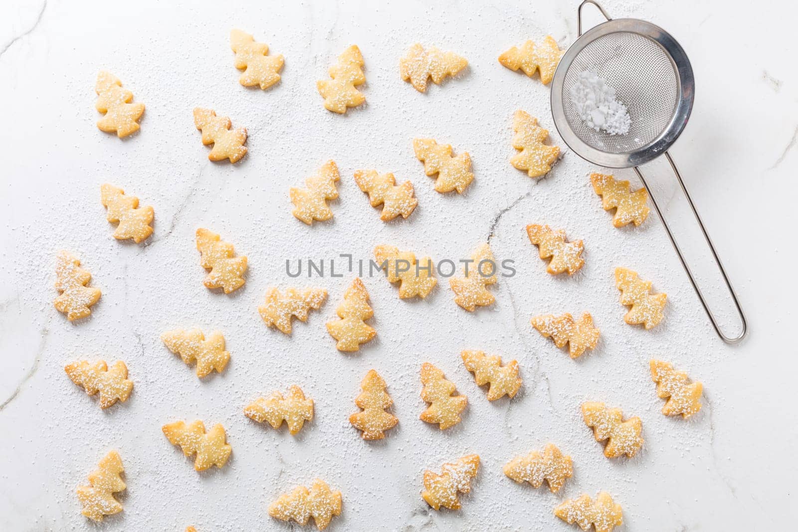 Homemade Christmas cookies in Christmas tree shape on marble background