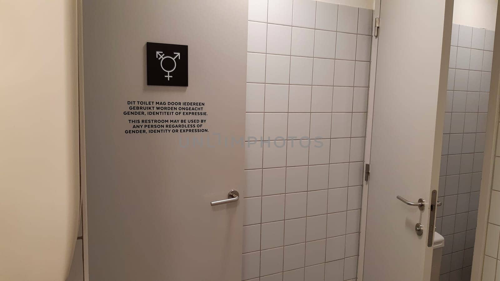 Antwerp, Belgium, May 2020: Gender neutral toilet symbol and sign on a door, in Dutch and English language