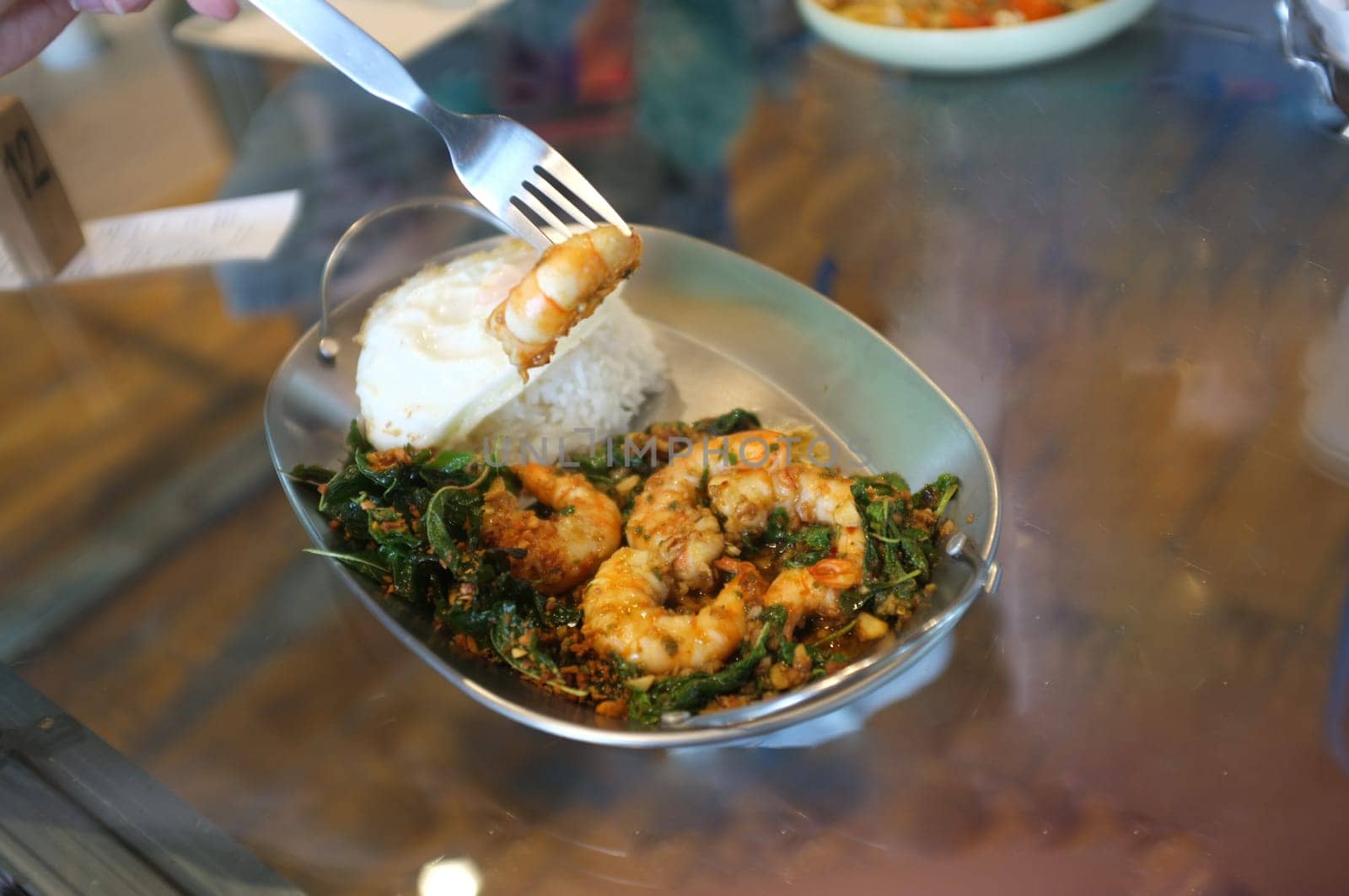 Stirred-fry shrimps or prawns with basil leaves, fried egg over rice. Thai food