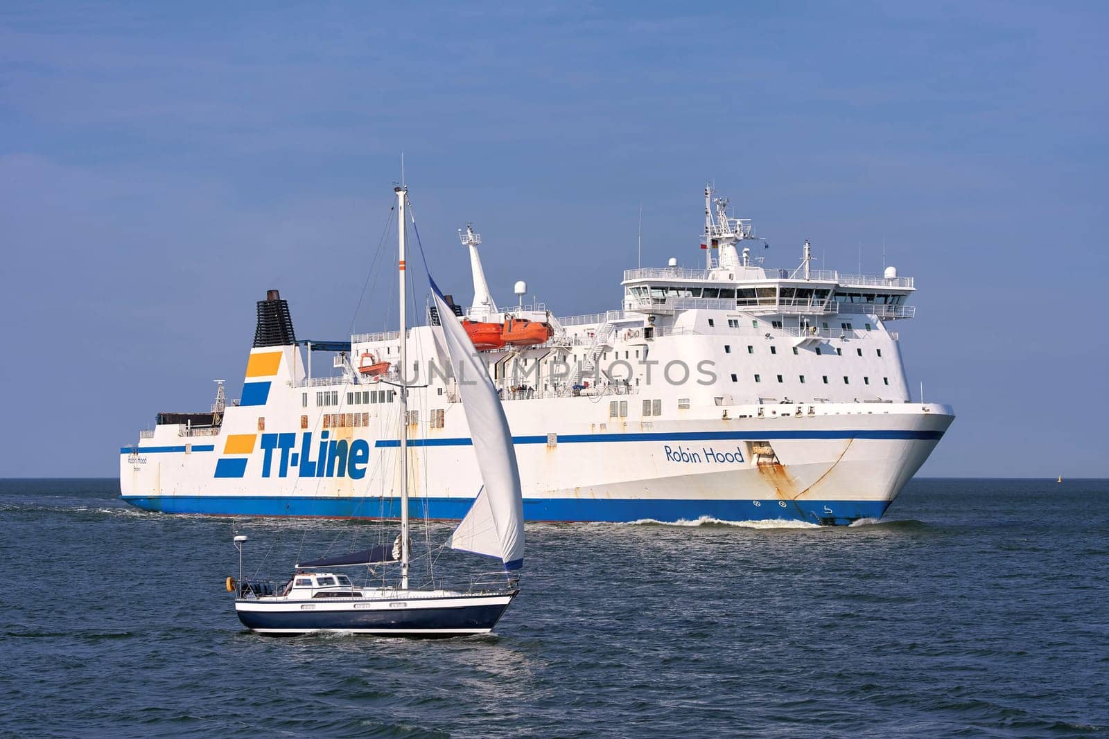 The ferry "Robin Hood"" and a sailing boat before entering the port of Swinoujscie on the Polish Baltic coast"