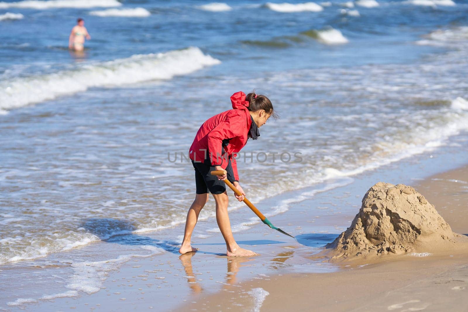 a girl on the beach of Swinoujscie in Poland building a sand castle