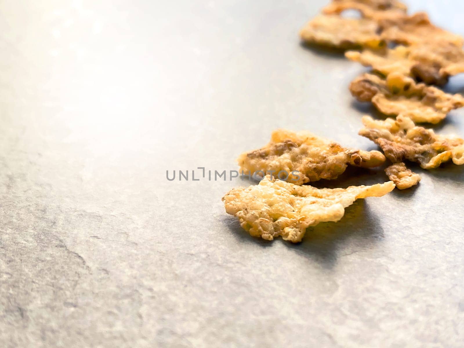 A group of corn flakes on a gray floor. Daily breakfast and nutrition