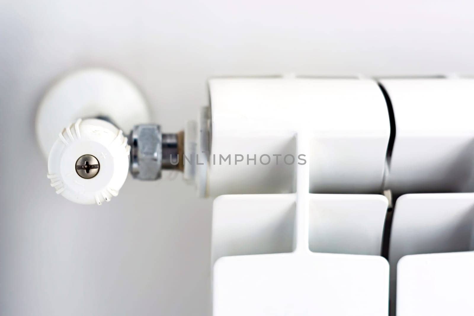 close-up view of the white knob that adjusts the temperature of the radiator. Heating and winter season