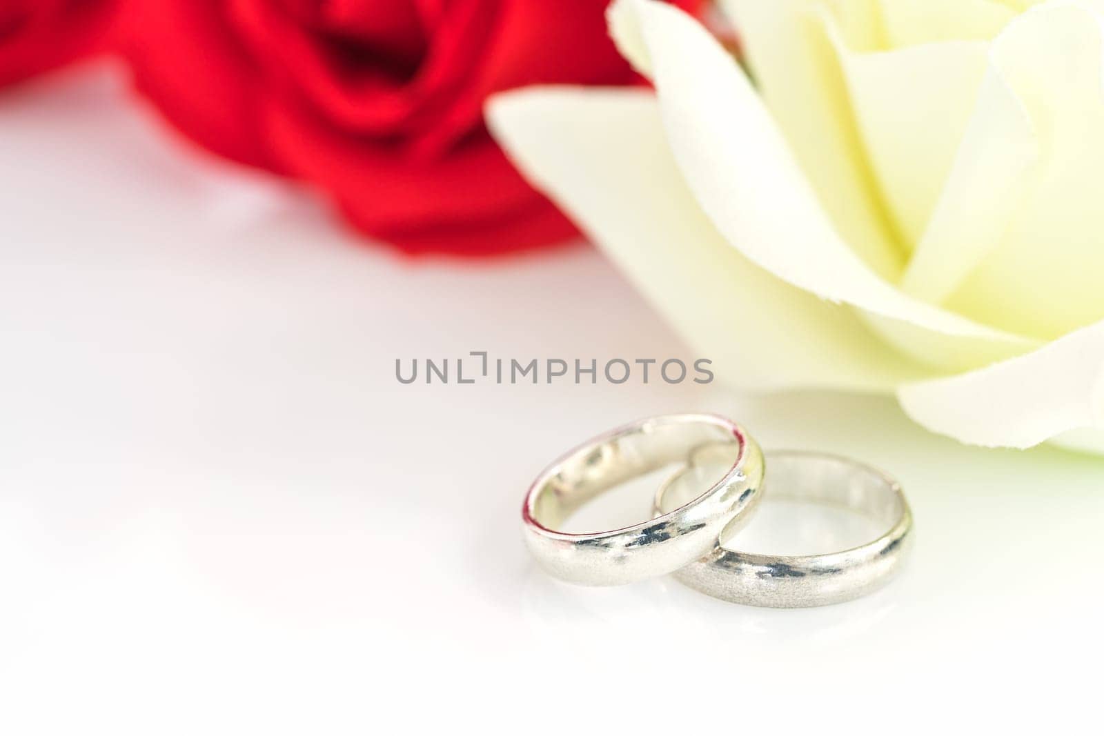 Close up red rose and wedding ring on white background, Wedding concept with roses and ring