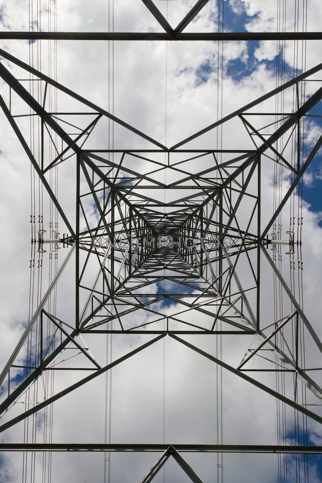 Abstract background texture image of power transmission lines running behind the metal lattice frame work of an electrical transmission tower.