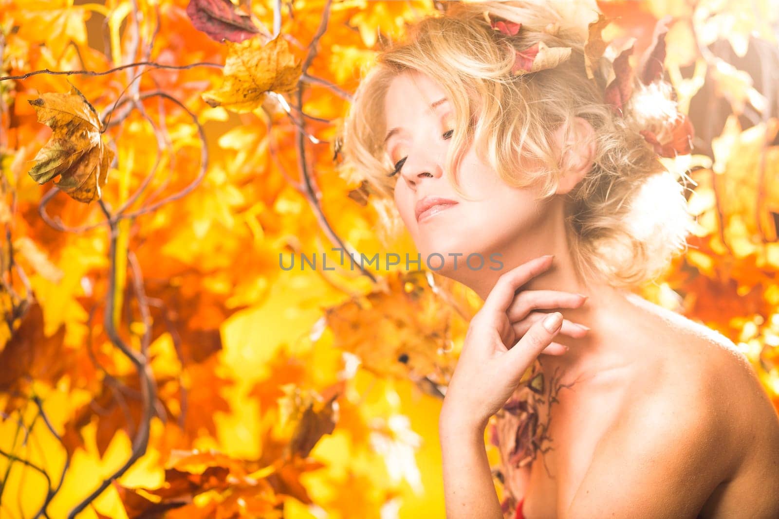 Fragile woman in autumn sun golden floral tree background