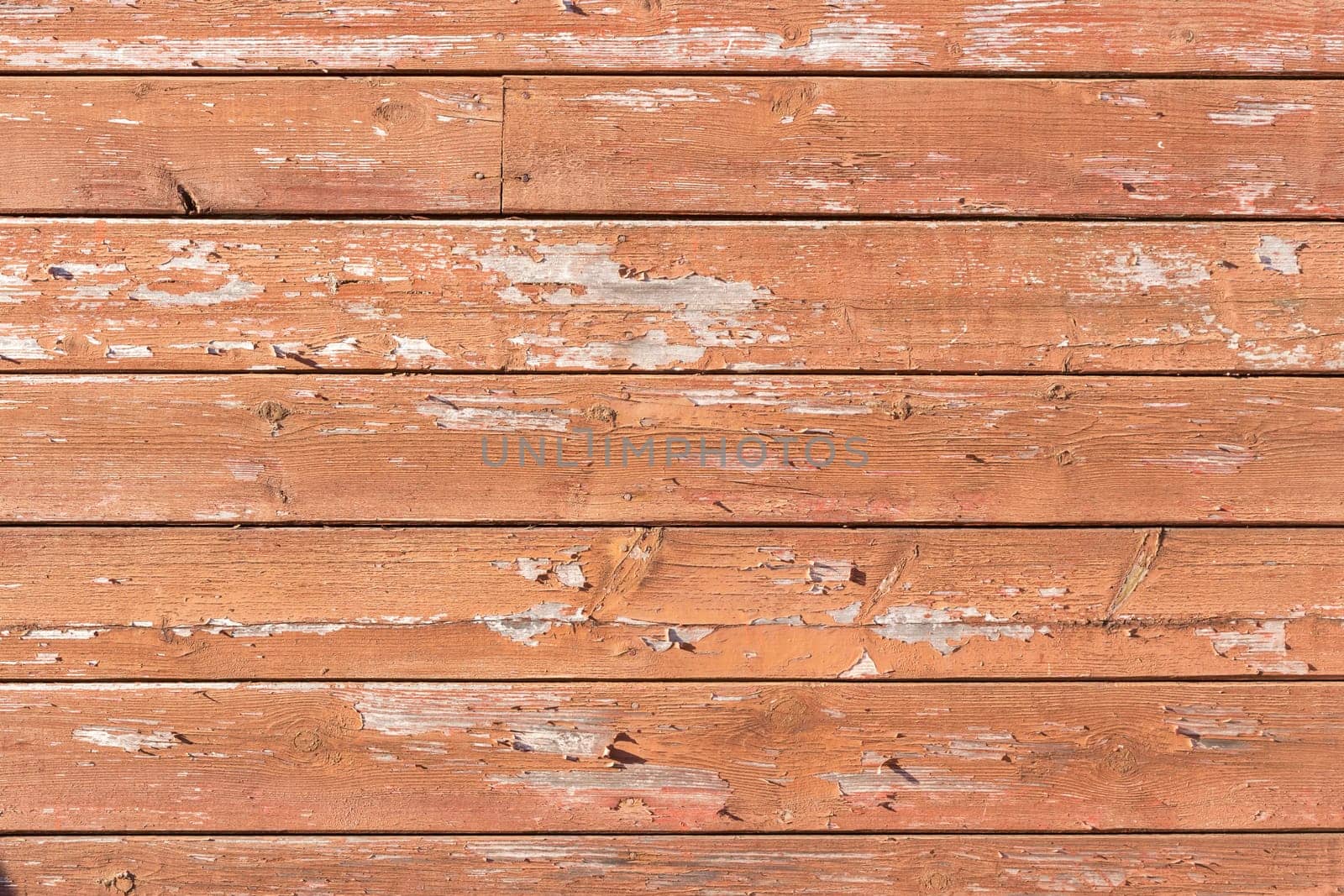 Texture of red paint peeling off boards