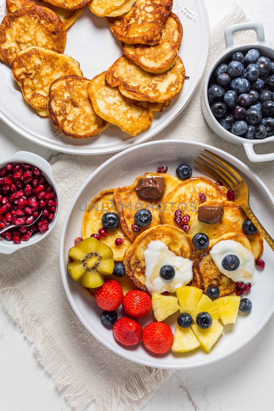 Homemade low calarie curd cheese pancakes with fruit salad and maple sirup