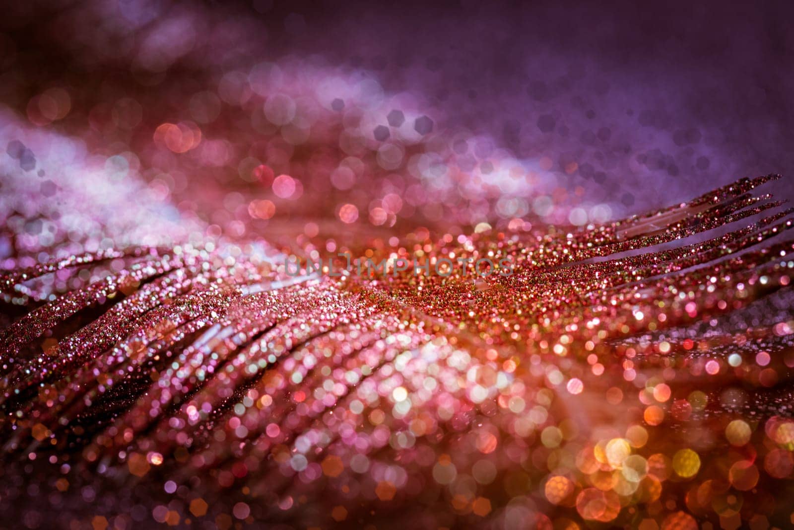 Abstract Christmas glitter and blurry background in red, golden and violet tones. Selective focus.
