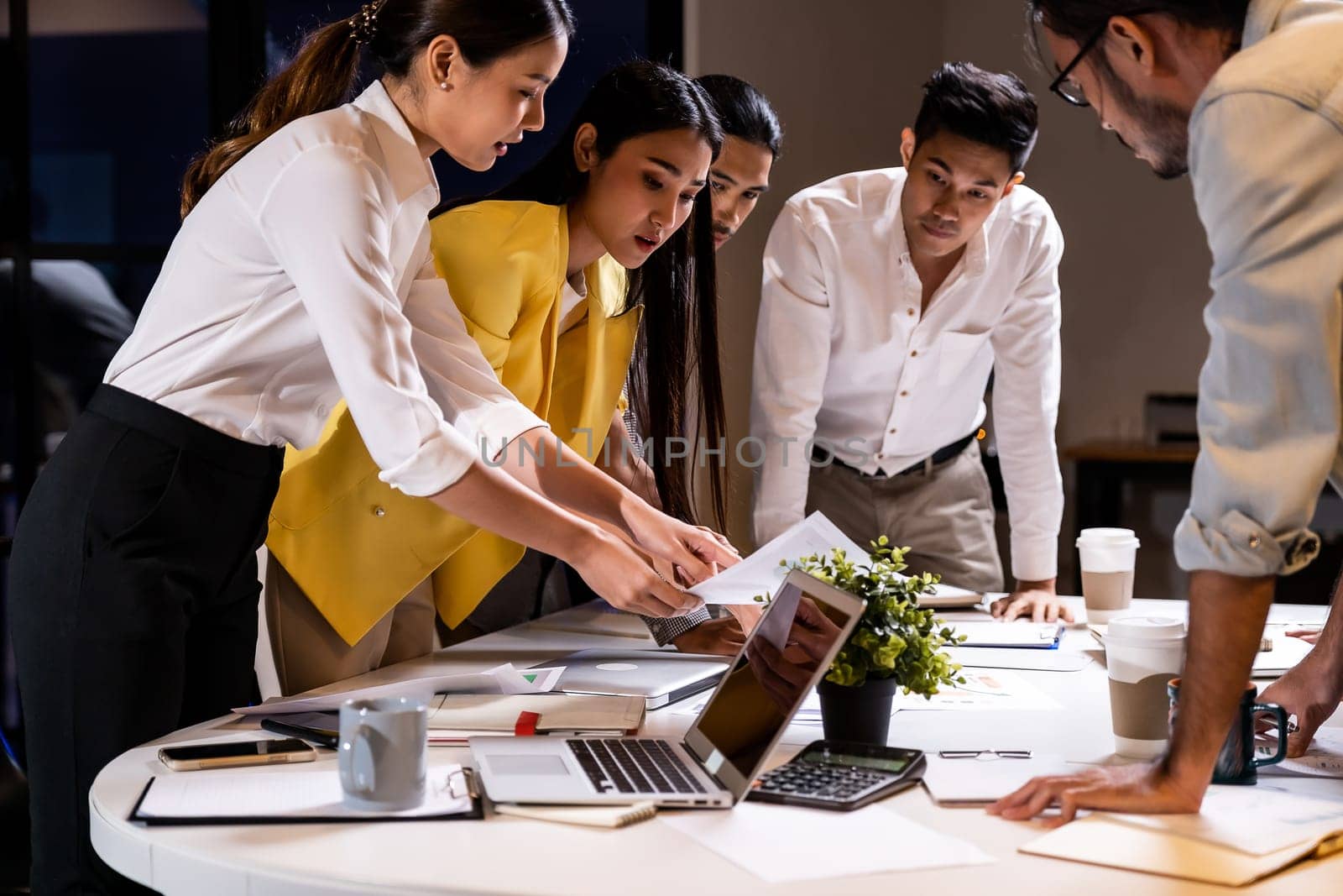 Work late concept of Interracial asian business team brainstorm idea at office meeting room at night. Work hard deadline and overtime working and new business start up concept.