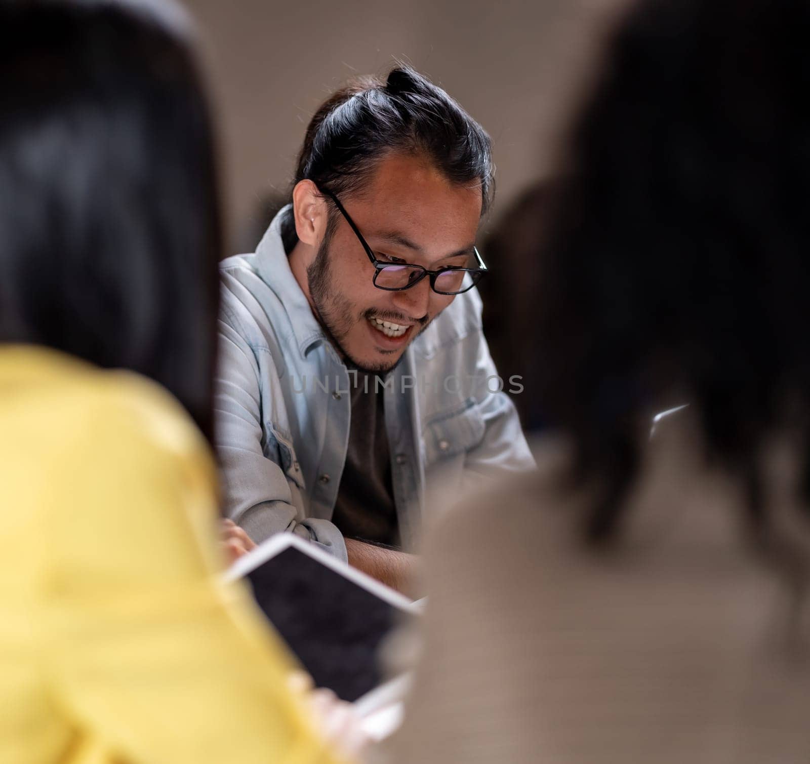 Portrait of Asian businessman working late having meeting with business team to brainstorm idea at office meeting room. Work hard deadline and overtime working and new business start up concept.