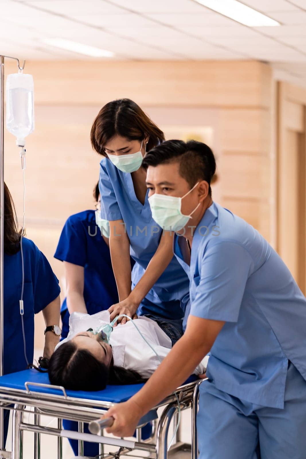 Close up Medical team do CPR to seriously injured patient with oxygen mask while push gurney stretcher bed to Operating Room. Emergency health care and medical hospital concept.