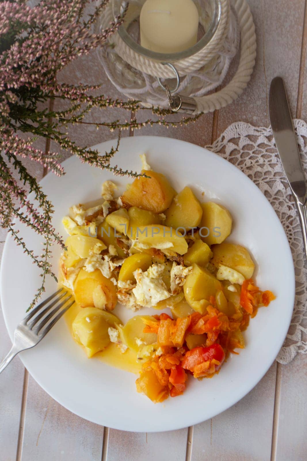 Boiled potatoes with vegetables on white plate. Flat view