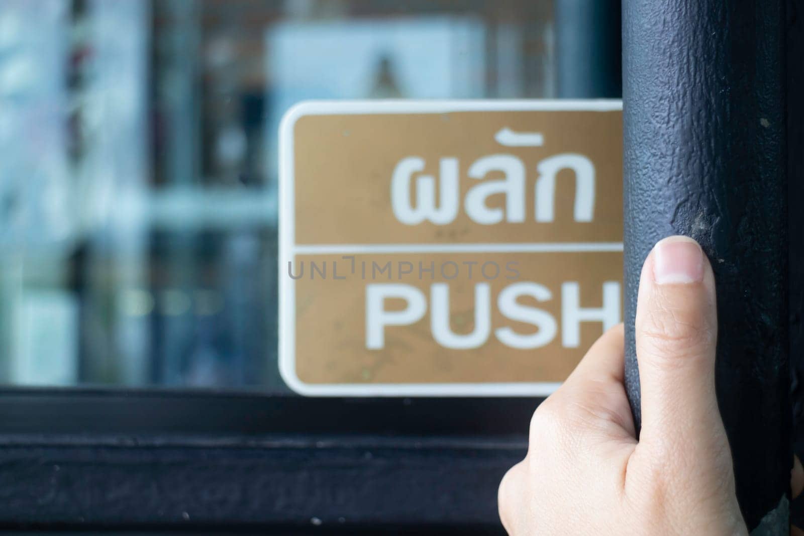 Hand on opening into store door, stock photo