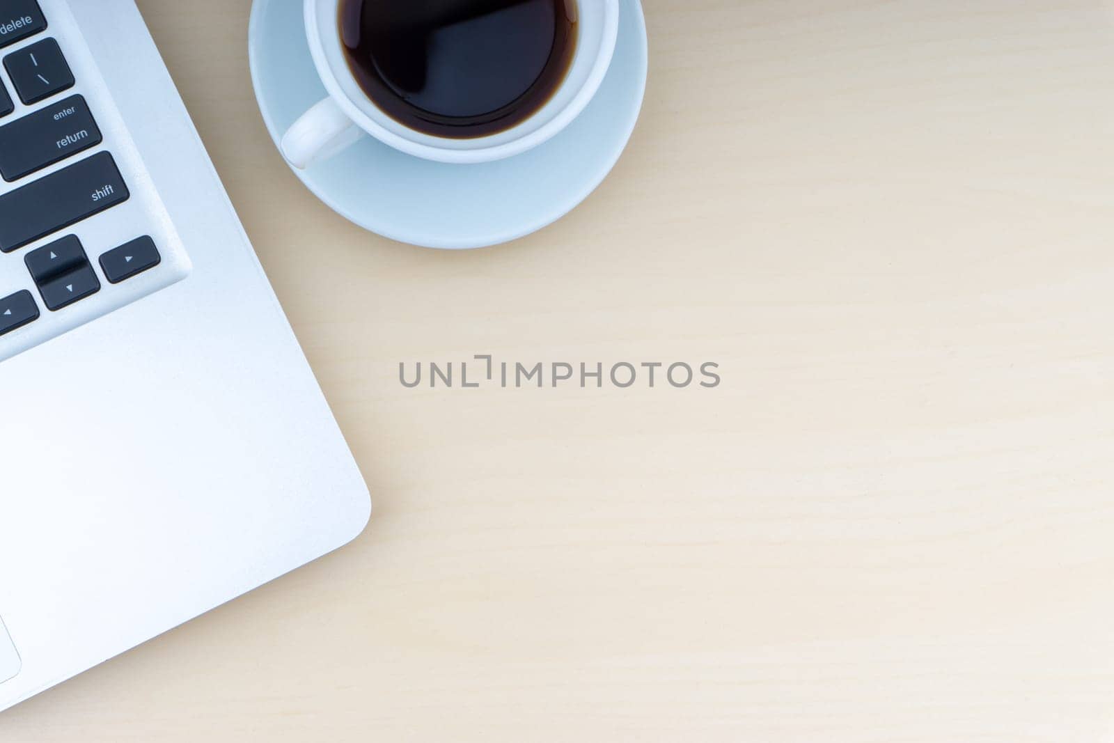 Laptop and cup of coffee on wooden background. Business and copy space concept..
