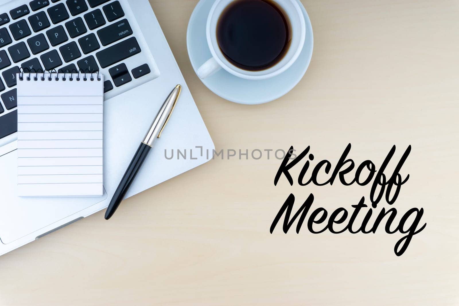 KICKOFF MEETING text with fountain pen, notepad, laptop and cup of coffee on wooden background. Business and copy space concept..