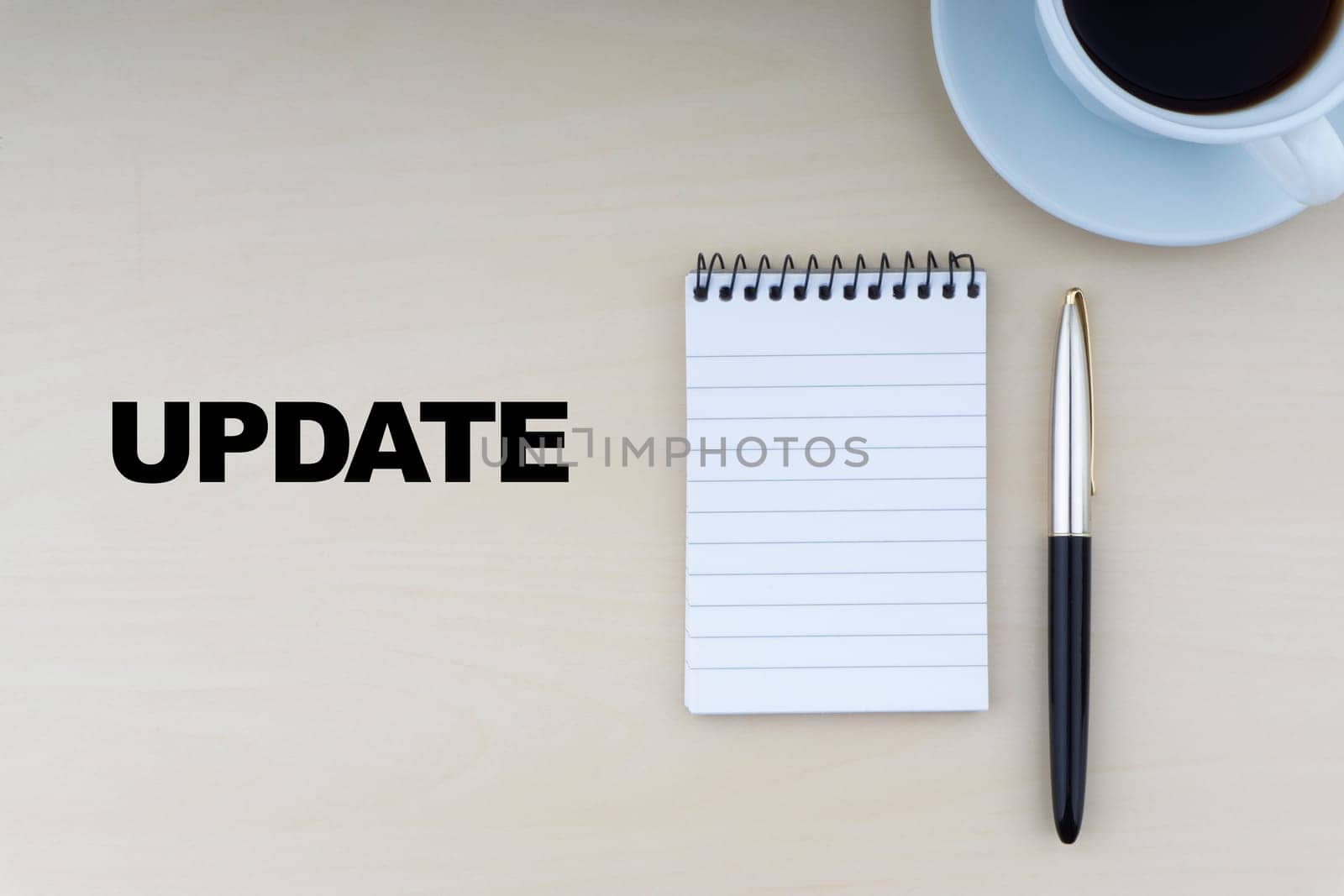 UPDATE text with fountain pen, notepad and cup of coffee on wooden background.Business and copy space concept..