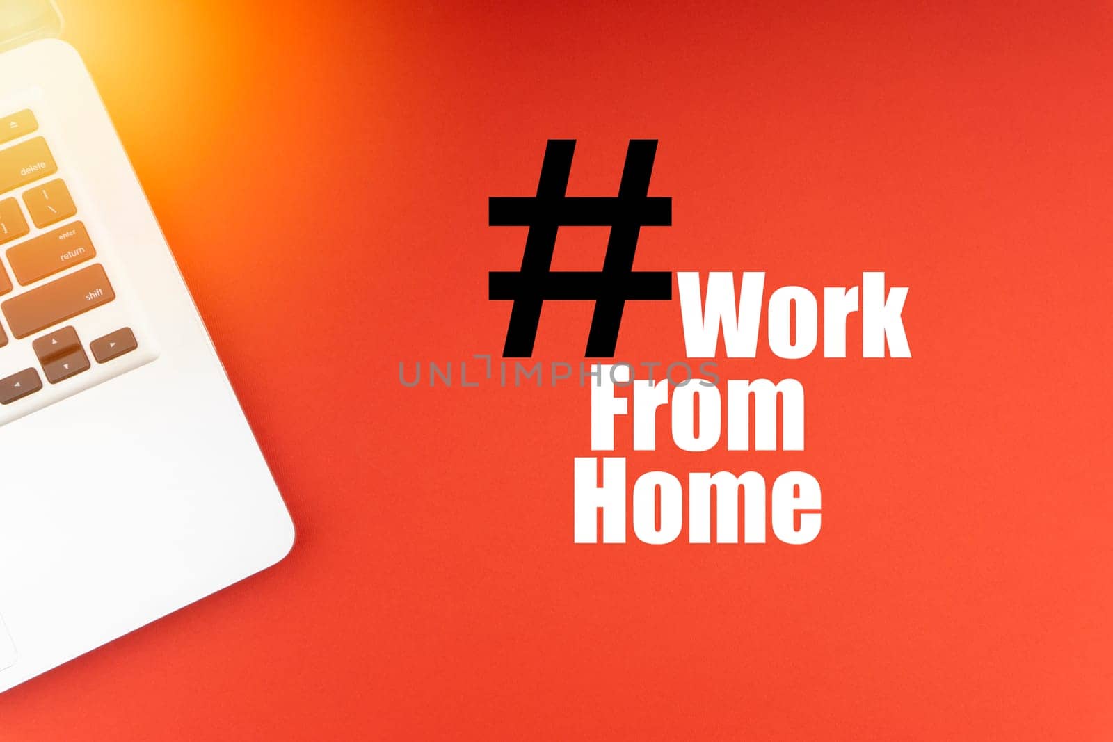 WORK FROM HOME text with laptop on red background. Business and Copy Space Concept