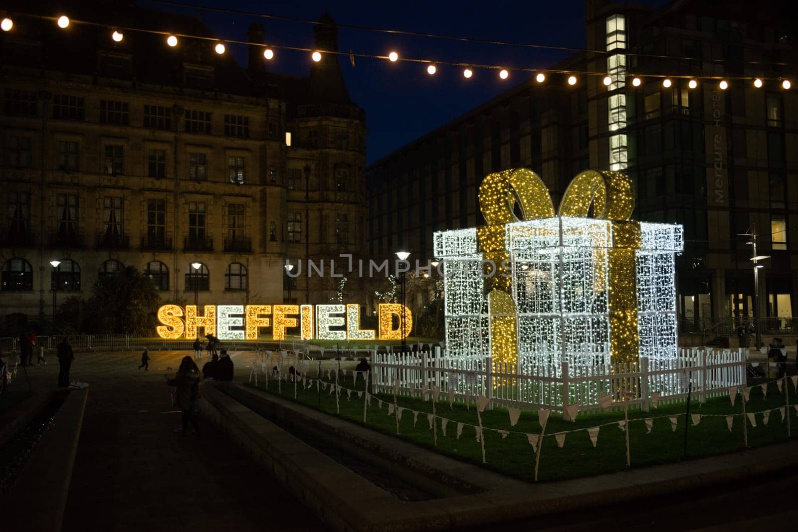 Sheffield, United Kingdom, 27th November, 2020: Lit up in fairy lights, the word sheffield, a large gift and light bulbs. Christmas light display 2020