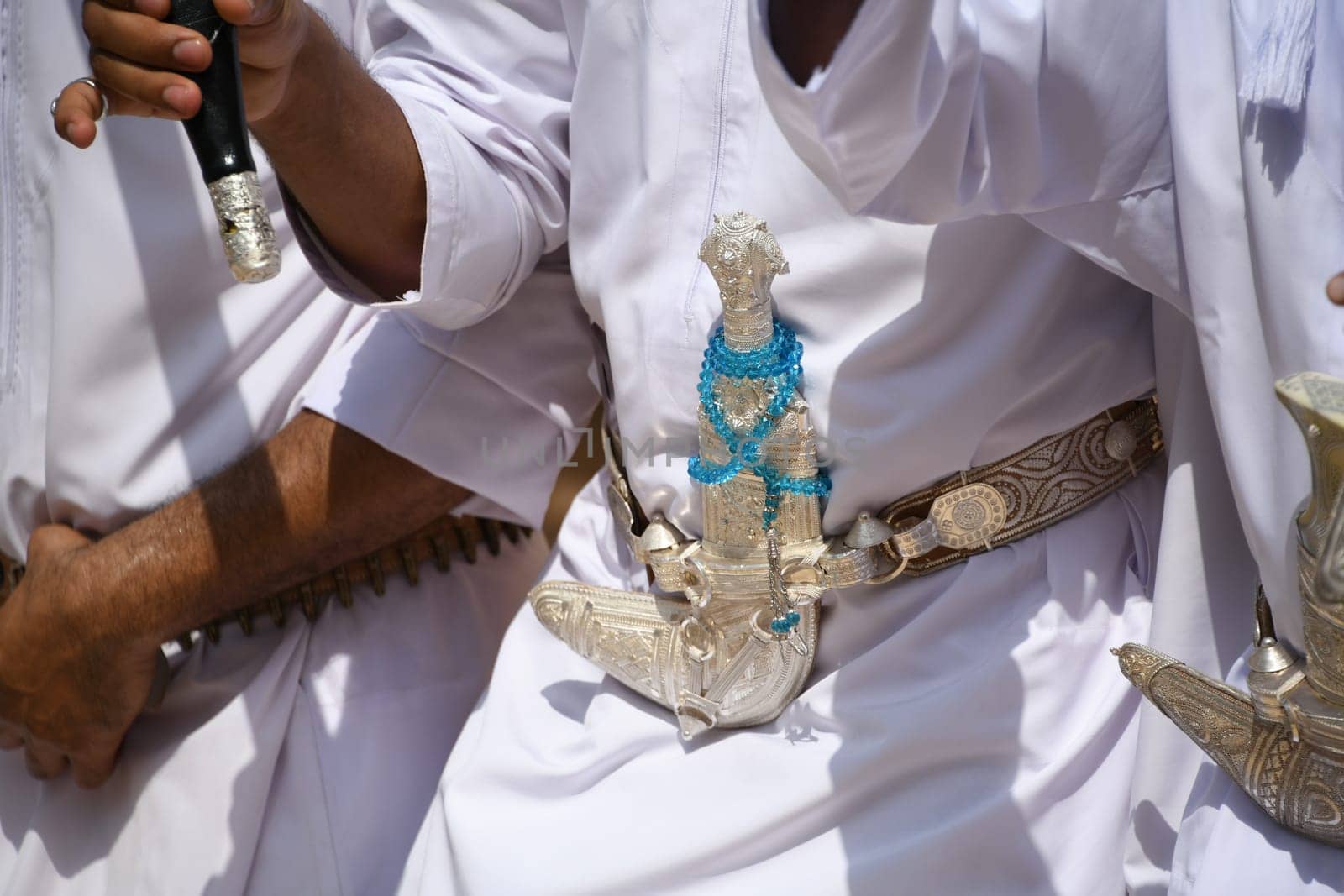 Men in Oman wear a scimitar dagger over the traditional robe of the Dishdasha
