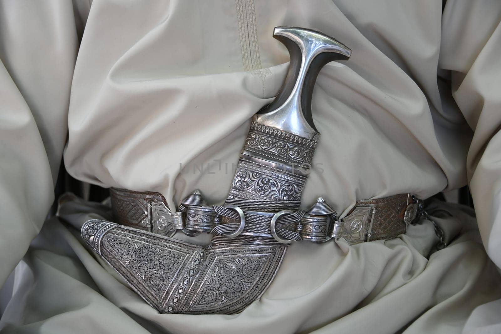On the traditional festive garment of the Dischdasha,Omani males wear a scimitar dagger as a status symbol