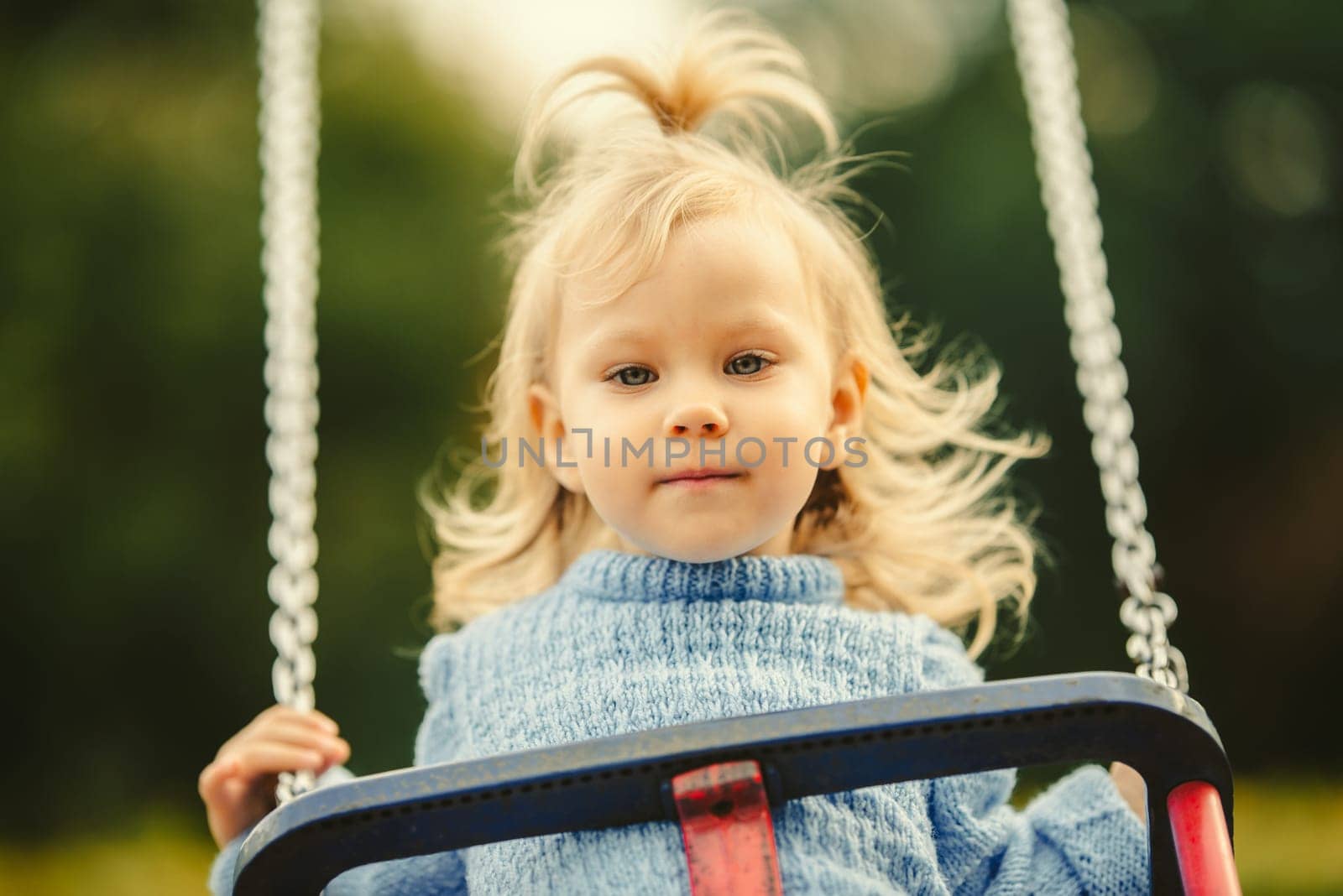 blonde haired girl on the swing