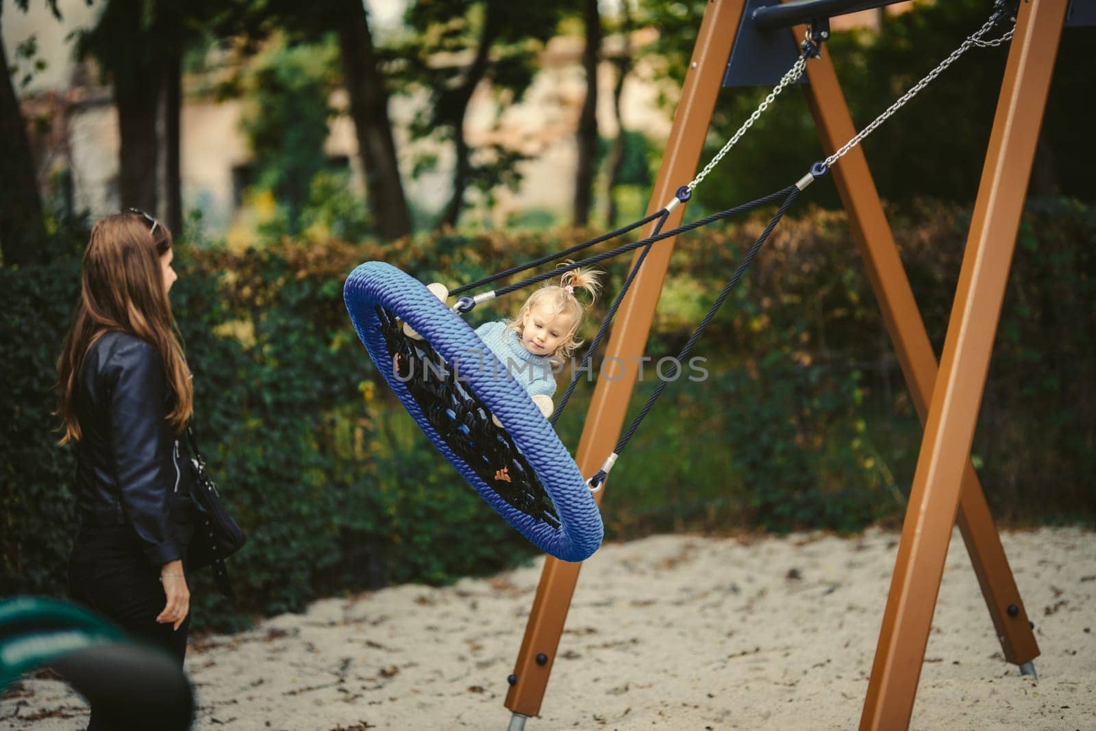 blonde haired girl on the swing
