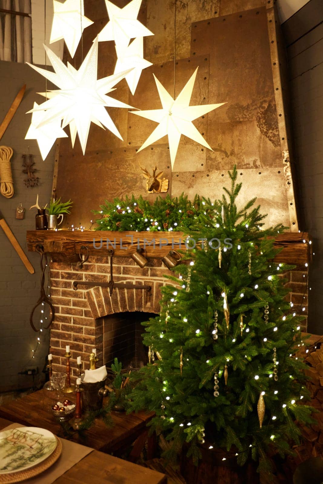 Home Christmas decoration interior late in night with light on xmas tree and fireplace.