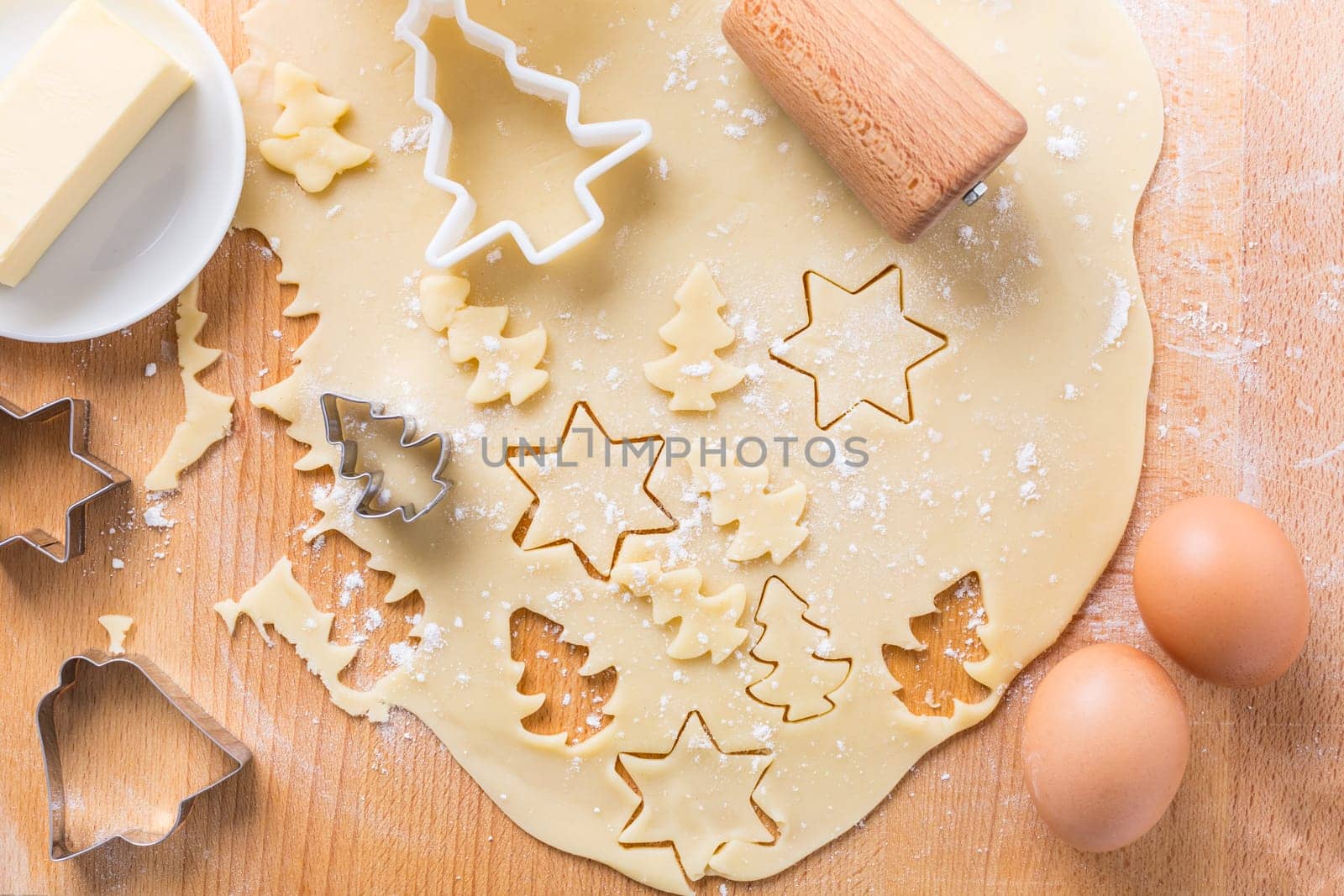 Christmas baking - dough with cookie cutter and baking ingredients. Homemade bakery, xmas sweet, winter holidays concept.