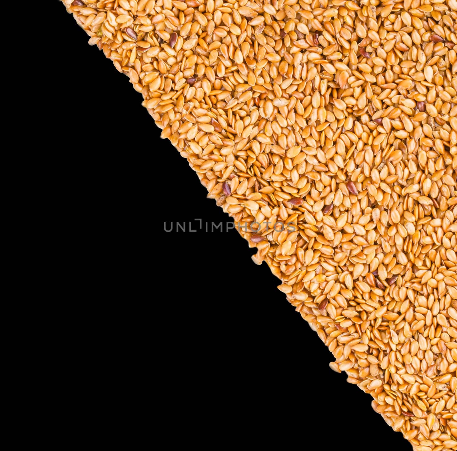 Background texture of roasted golden flax seed or linseed with healthy omega-3 fatty acids, dietary fiber, rich in oils and used to lower cholesterol