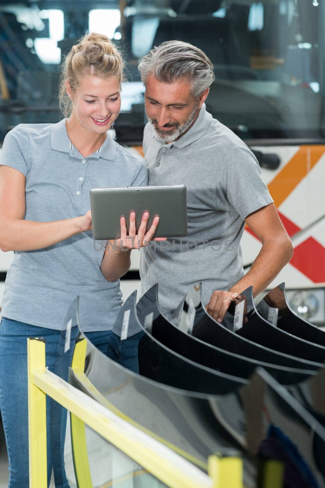 workers in bus garage looking at digital tablet