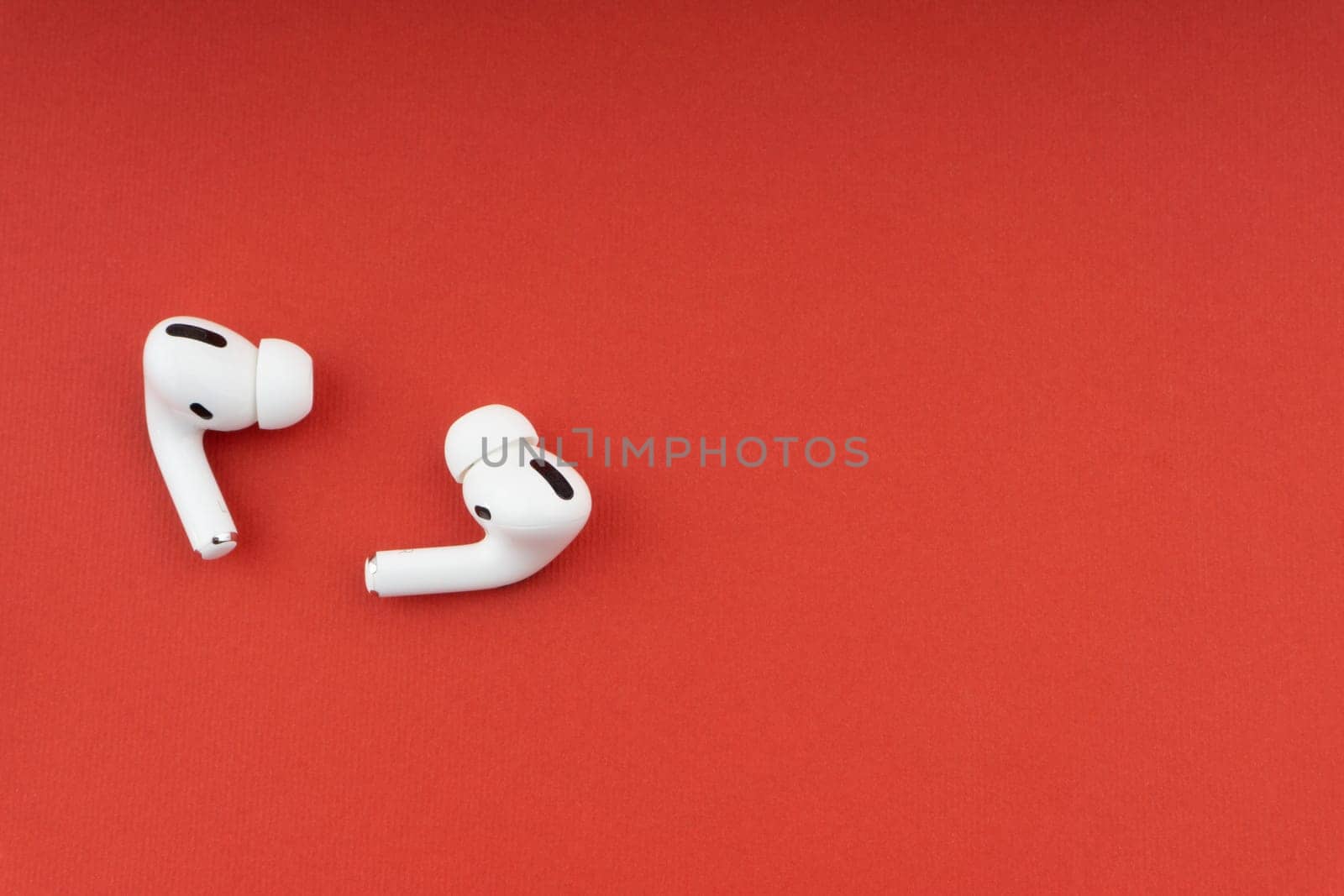 Kuala Lumpur, Malaysia - December 1,2020 : AirPods Pro on red background