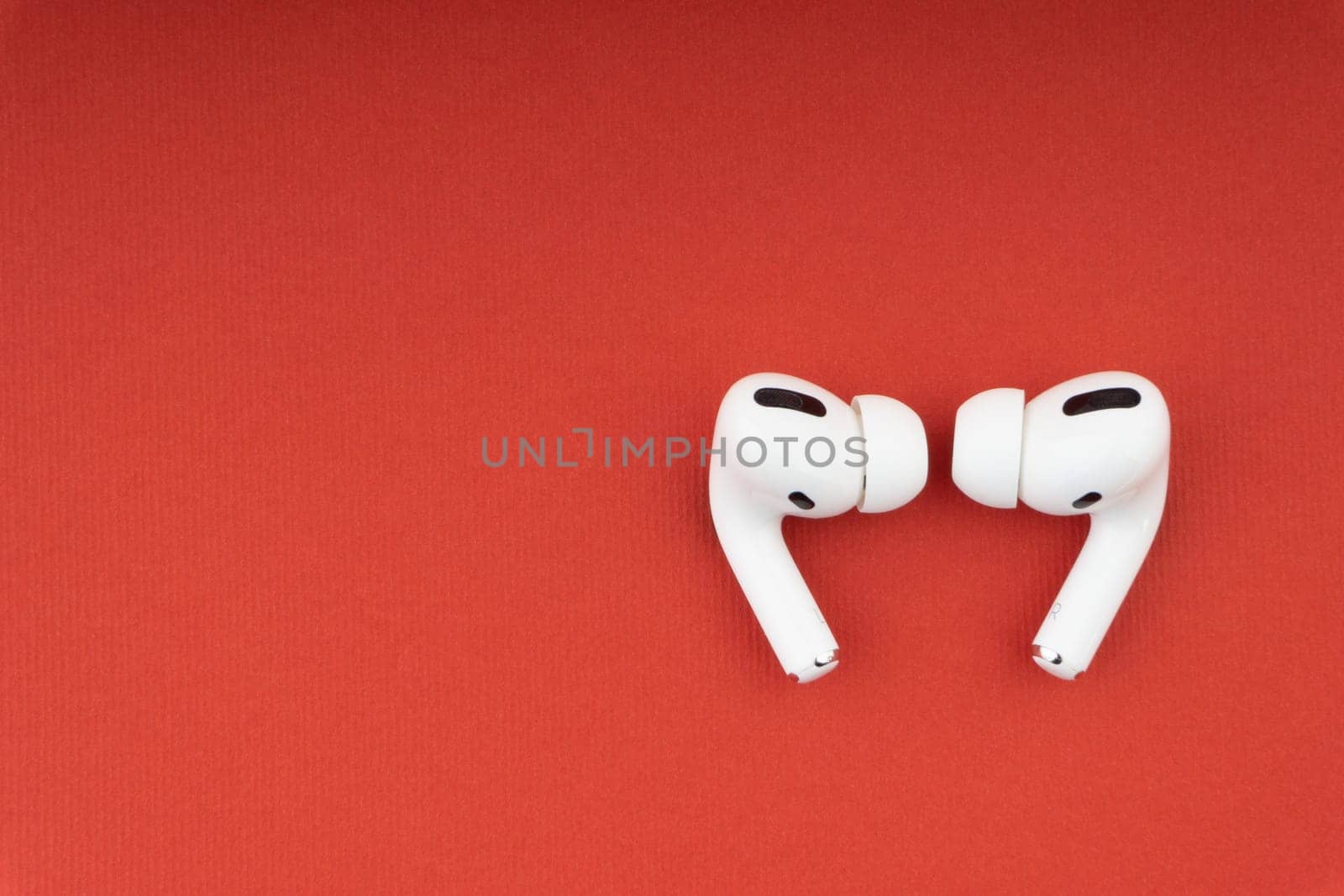 Kuala Lumpur, Malaysia - December 1,2020 : AirPods Pro on red background