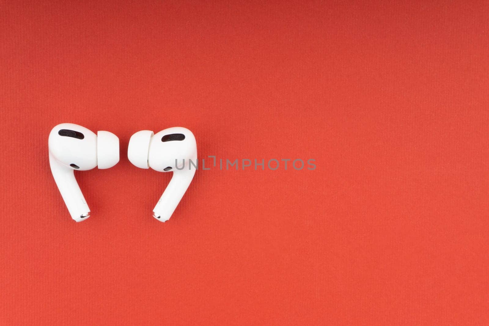 Kuala Lumpur, Malaysia - December 1,2020 : AirPods Pro on red background